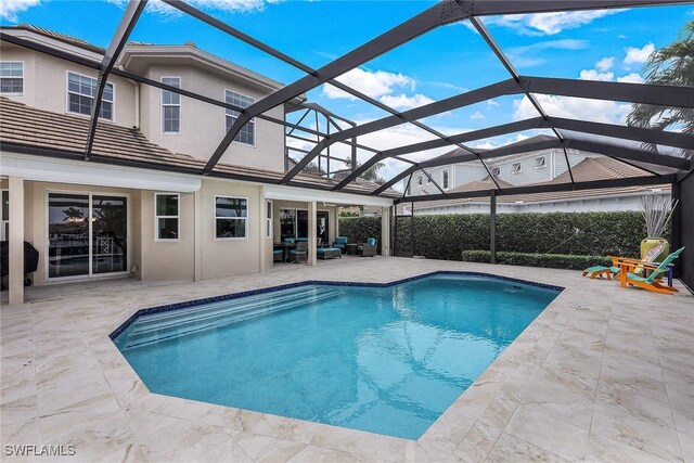 view of swimming pool featuring a lanai and a patio