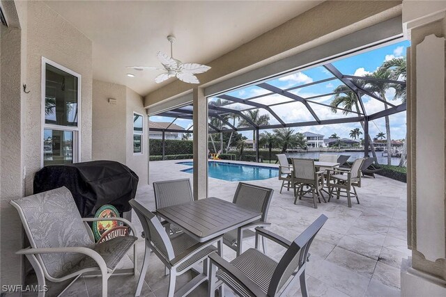 view of patio / terrace featuring a lanai, a water view, and ceiling fan