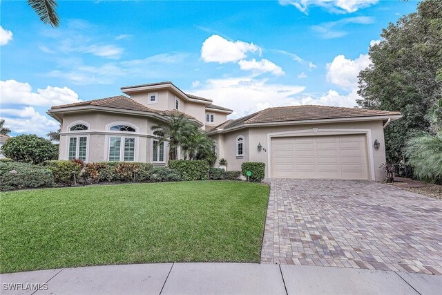 mediterranean / spanish home with a front yard and a garage