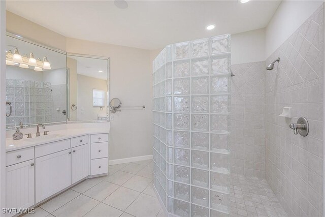 bathroom featuring vanity, tile patterned flooring, and tiled shower