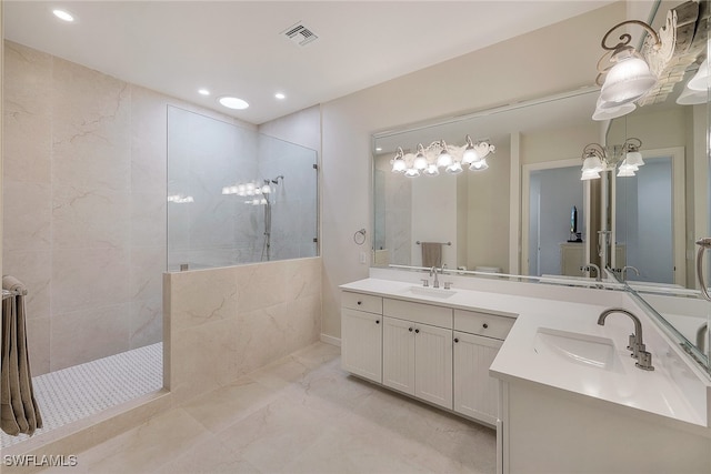 bathroom with tiled shower and vanity