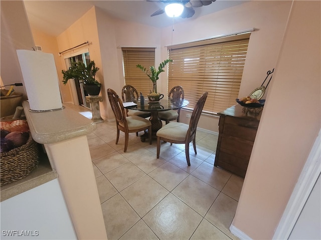 tiled dining room with vaulted ceiling, ceiling fan, and decorative columns