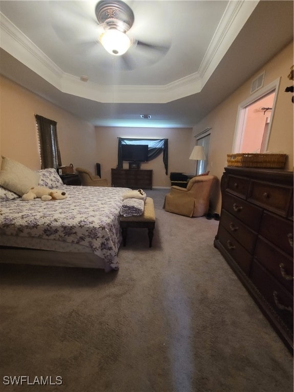 bedroom featuring ceiling fan, ornamental molding, carpet floors, and a tray ceiling