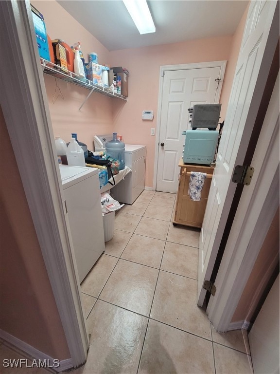 laundry room with independent washer and dryer and light tile patterned flooring