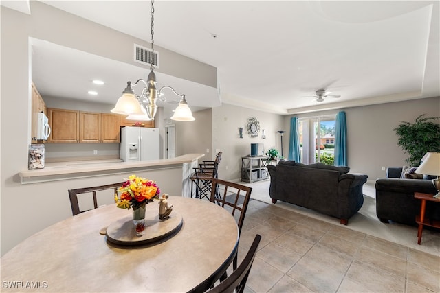 dining space featuring ceiling fan with notable chandelier and light tile patterned floors