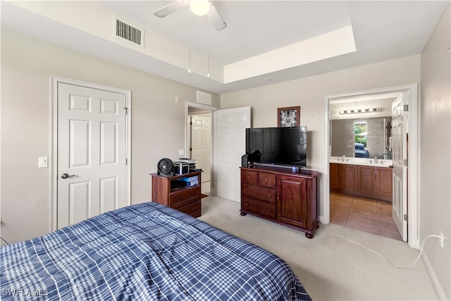 bedroom with connected bathroom, sink, ceiling fan, and light colored carpet