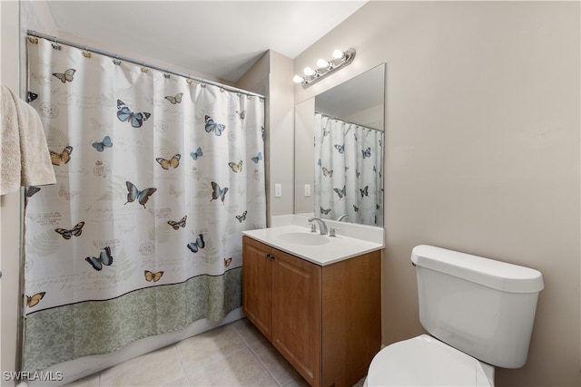 bathroom featuring tile patterned floors, curtained shower, vanity, and toilet