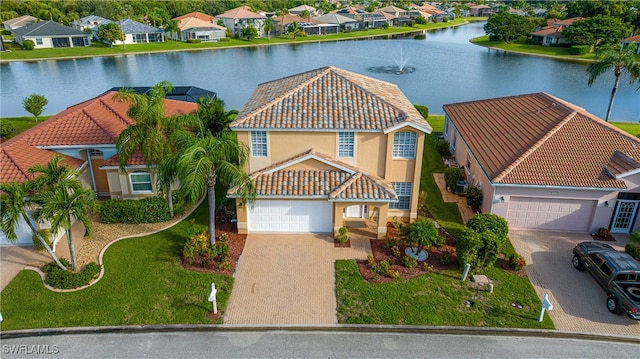 view of front of house featuring a front yard, a garage, and a water view