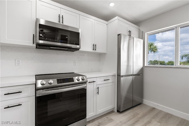 kitchen featuring white cabinets, stainless steel appliances, light countertops, and baseboards