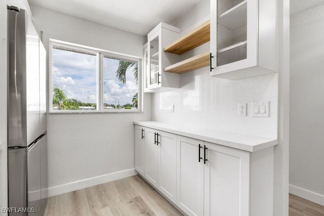 kitchen featuring white cabinetry, light hardwood / wood-style floors, and stainless steel refrigerator