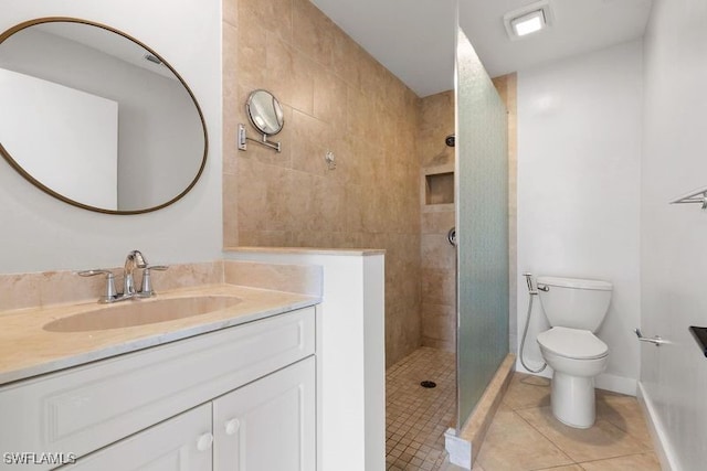 bathroom with vanity, tile patterned floors, toilet, and tiled shower