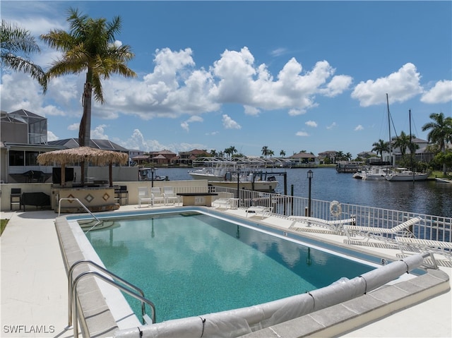 view of swimming pool featuring a water view and a patio area