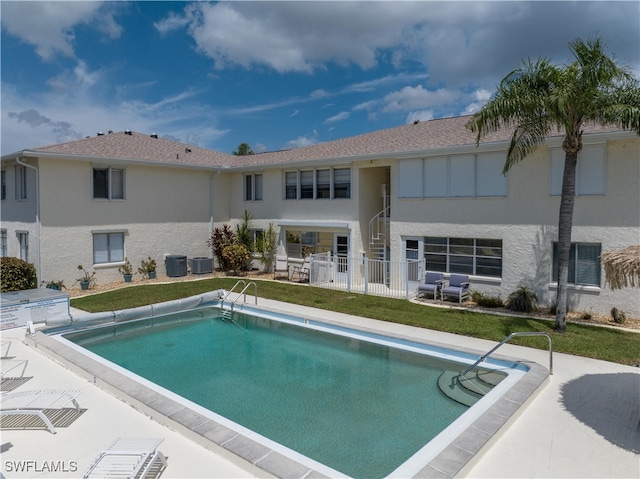 view of pool with a lawn, a patio, and central AC