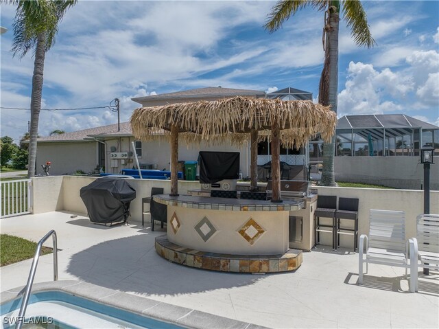 view of patio featuring area for grilling, exterior bar, and an outdoor kitchen