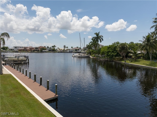 view of dock with a yard and a water view