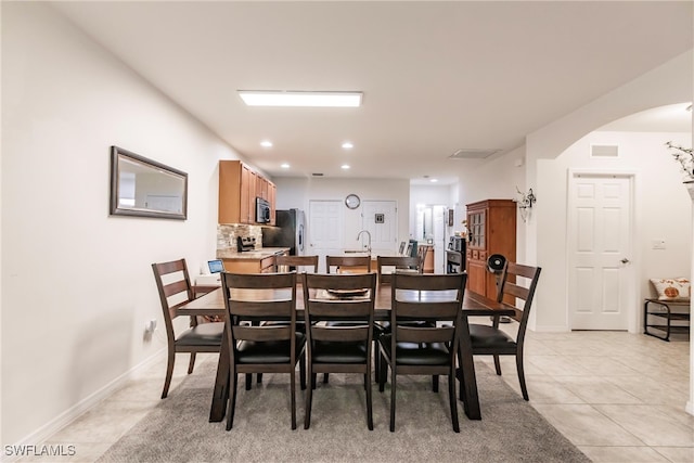 dining space featuring sink and light tile patterned floors