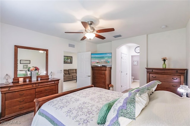 carpeted bedroom featuring ceiling fan and ensuite bath