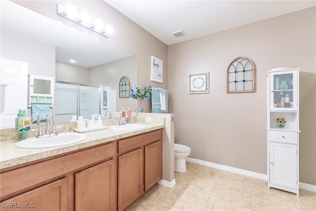 bathroom featuring tile patterned floors, walk in shower, vanity, and toilet