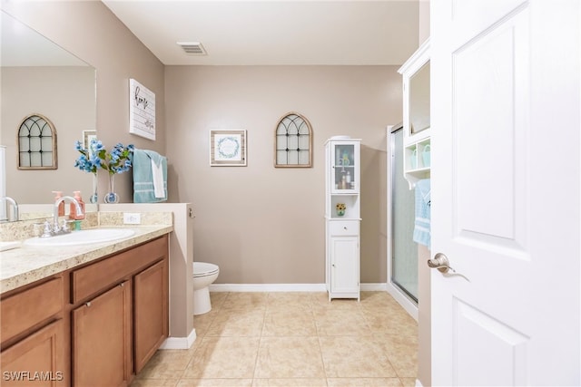 bathroom featuring vanity, toilet, tile patterned floors, and an enclosed shower