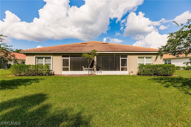 rear view of property featuring a lawn