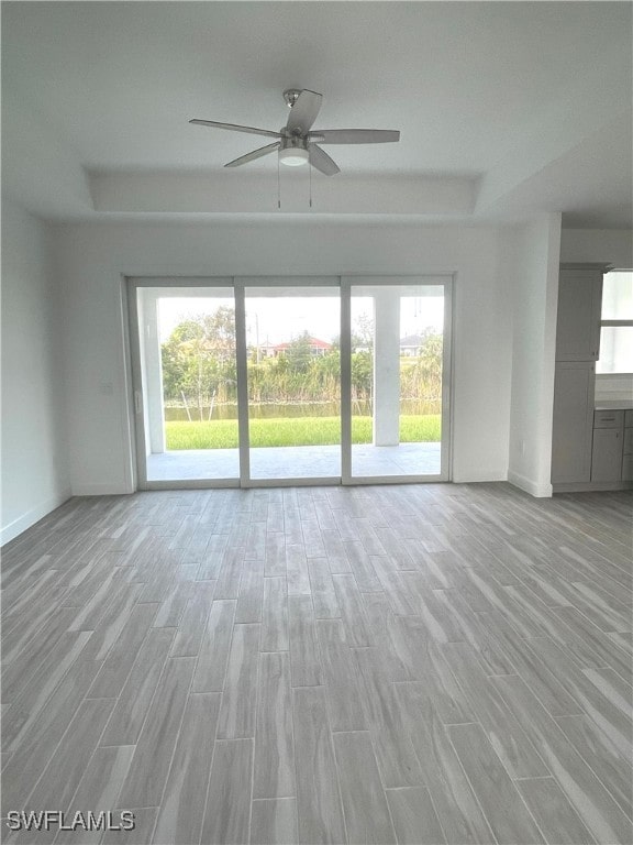 unfurnished living room with a wealth of natural light, light hardwood / wood-style flooring, and ceiling fan