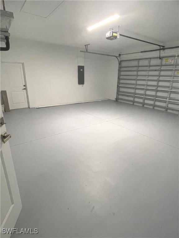 garage with a garage door opener and electric panel