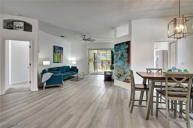 dining room featuring light wood-type flooring and ceiling fan with notable chandelier