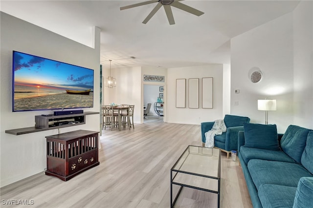 living room featuring ceiling fan with notable chandelier and light hardwood / wood-style floors