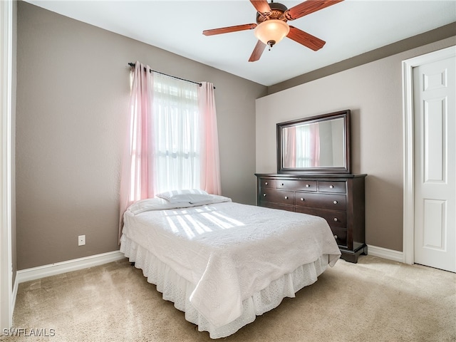 bedroom featuring light colored carpet and ceiling fan