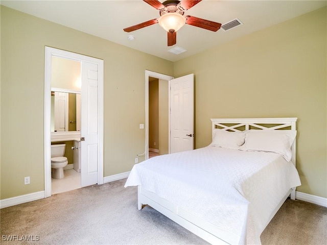 carpeted bedroom with ceiling fan and ensuite bath