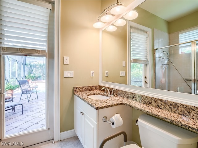 bathroom featuring vanity, a shower with shower door, and toilet