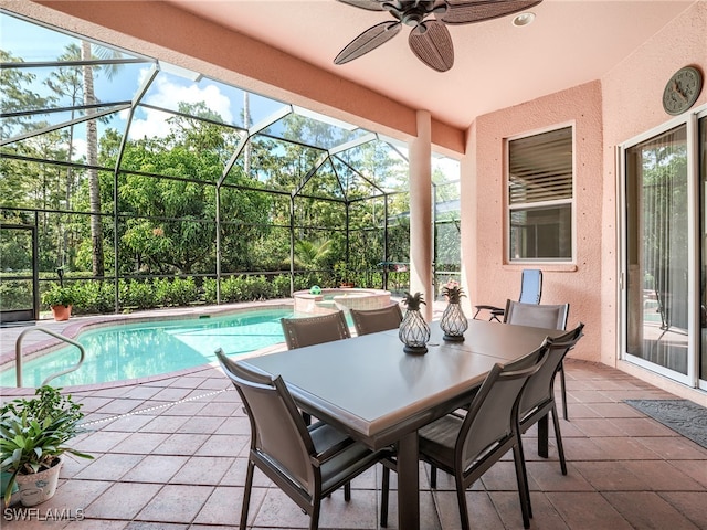 view of swimming pool with a patio area, an in ground hot tub, ceiling fan, and glass enclosure