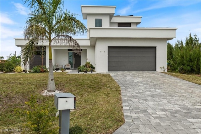 view of front facade with decorative driveway, a front lawn, and stucco siding