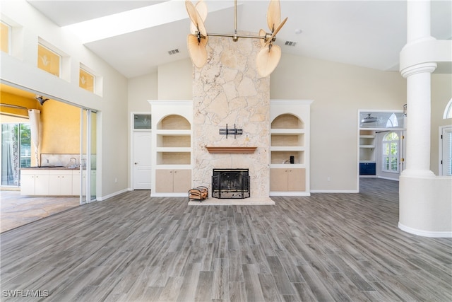 unfurnished living room featuring high vaulted ceiling, a fireplace, and hardwood / wood-style floors