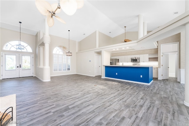 kitchen featuring light wood-type flooring, appliances with stainless steel finishes, ceiling fan, and high vaulted ceiling