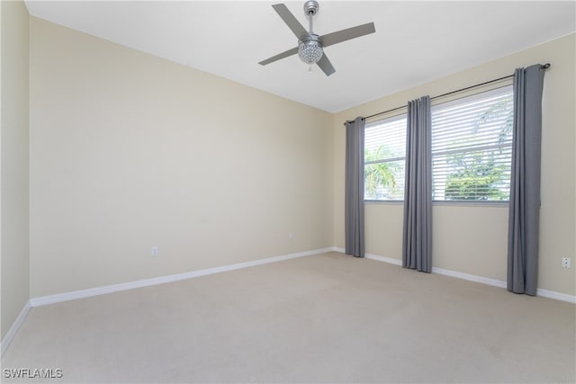 spare room with ceiling fan and light colored carpet