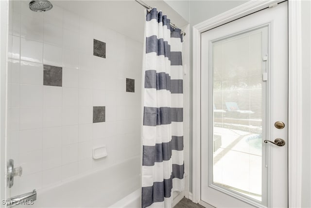 bathroom with shower / bath combo with shower curtain and a wealth of natural light