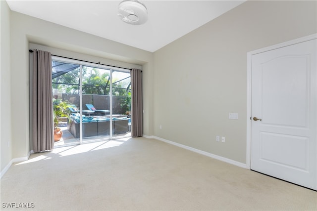 spare room with lofted ceiling and light colored carpet