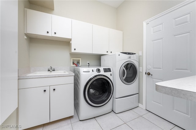 washroom with washer and clothes dryer, cabinets, sink, and light tile patterned flooring