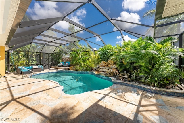 view of pool with glass enclosure and a patio area