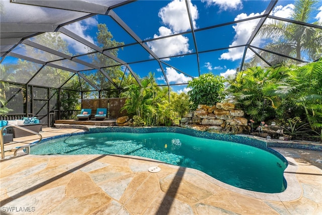 view of swimming pool with a lanai, an outdoor living space, and a patio