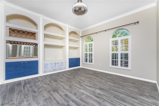 spare room with wood-type flooring, ornamental molding, and built in features