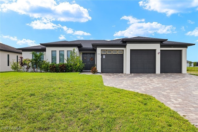 prairie-style house featuring a garage and a front lawn