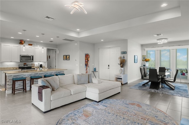 living room featuring light tile patterned flooring and an inviting chandelier