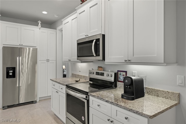 kitchen with white cabinetry, stainless steel appliances, and light stone counters