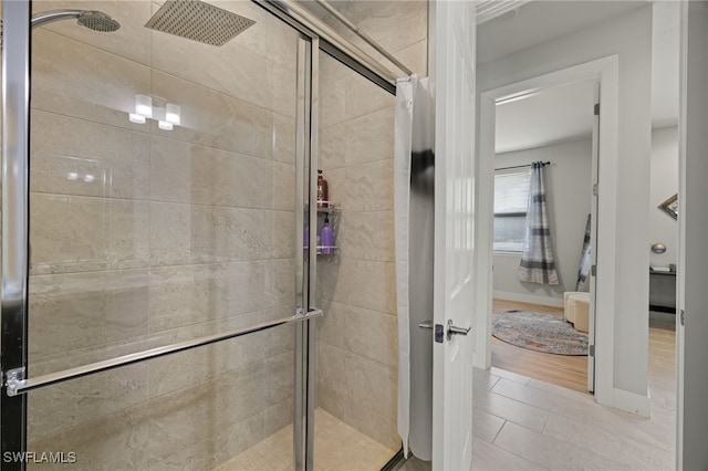 bathroom with hardwood / wood-style flooring and a shower with shower door