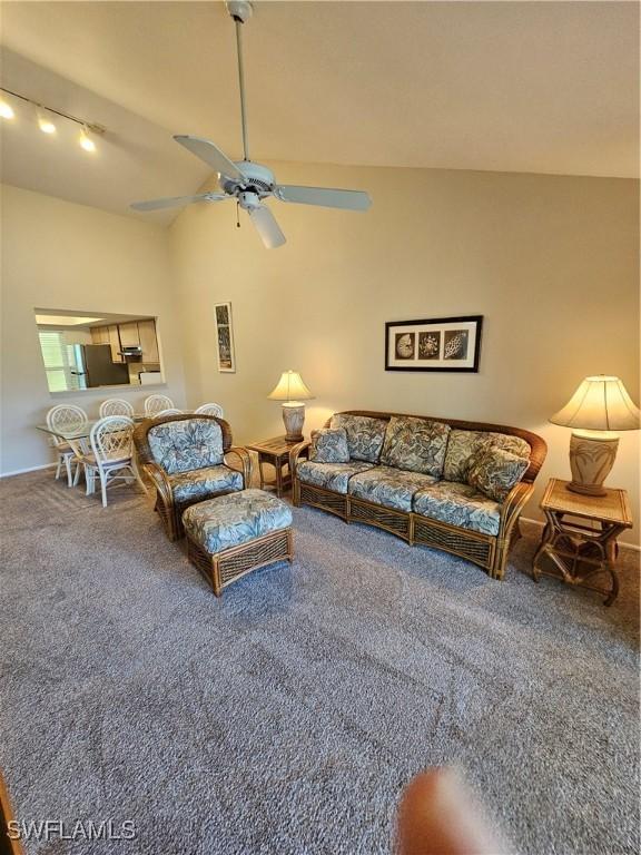 carpeted living room with vaulted ceiling, rail lighting, and ceiling fan