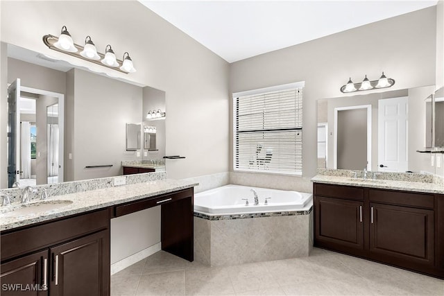 bathroom featuring tile patterned floors, vanity, and a relaxing tiled tub