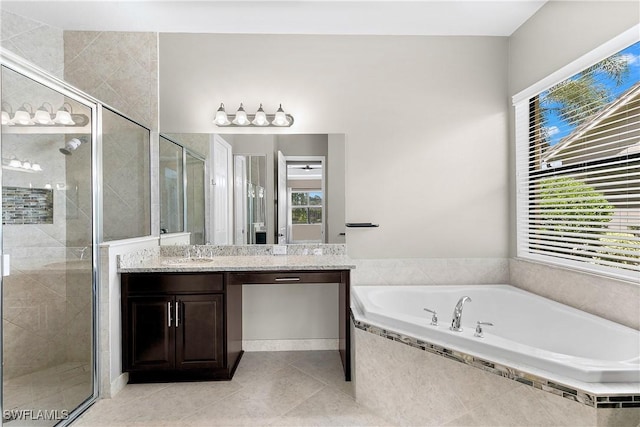 bathroom with plus walk in shower, vanity, plenty of natural light, and tile patterned flooring