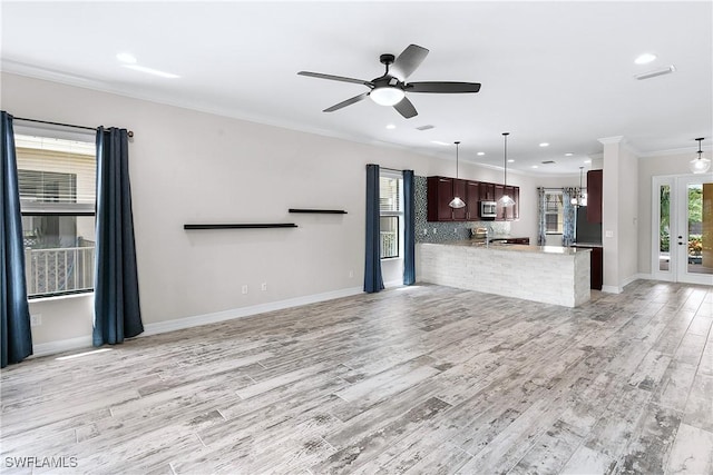 kitchen featuring kitchen peninsula, pendant lighting, a wealth of natural light, and ornamental molding